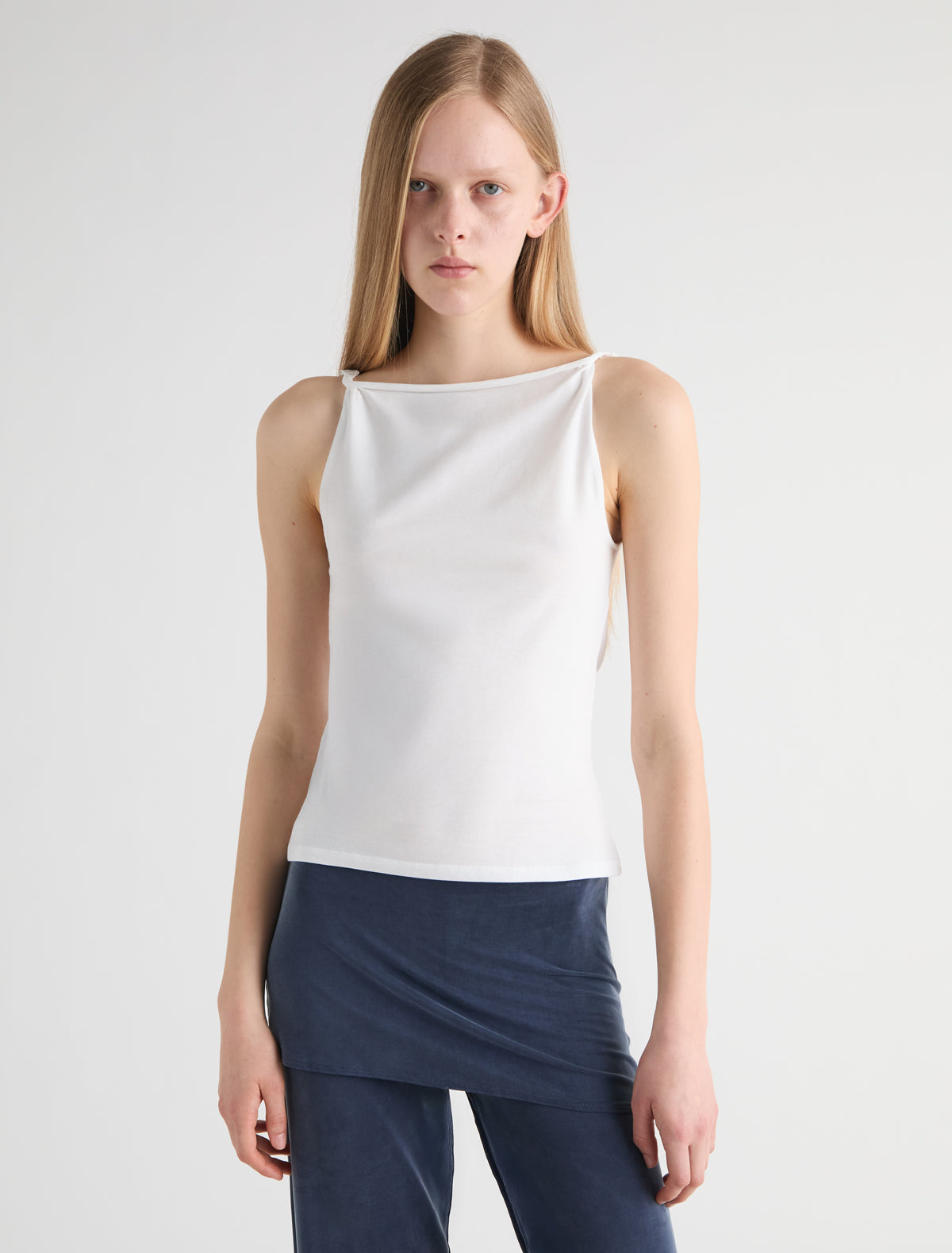 SIMP-White sleeveless top featuring twisted shoulder details