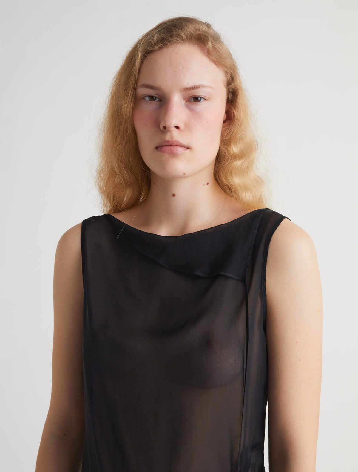 SATO-Black sleeveless asymmetric top with a cut at the hem ribbons