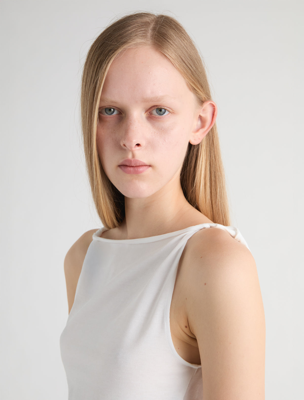 SIMP-White sleeveless top featuring twisted shoulder details